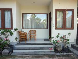 a porch of a house with two chairs and a table at Kubu Di-Kayla's in Sanur