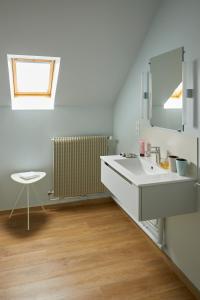 a bathroom with a sink and a mirror and a chair at Maison Familiale le Maréchal in Doudeville