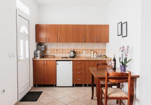 a kitchen with a table and a white refrigerator at Guest House Lalic in Bar