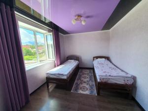 a small room with two beds and a window at MALIKA Guest House in Kochkorka