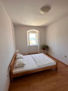 ein Schlafzimmer mit einem Bett in einem Zimmer mit einem Fenster in der Unterkunft UNA apartment in center of Mali Lošinj in Mali Lošinj