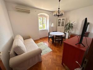 a living room with a white couch and a table at UNA apartment in center of Mali Lošinj in Mali Lošinj