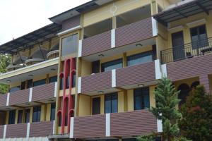 a building with wooden balconies on the side of it at Hotel Toba Shanda By Helocus in Parapat