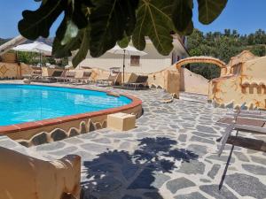 a swimming pool with chairs and a resort at Villa Su Navru in Irgoli