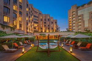 a courtyard with chairs and umbrellas and a pool at ITC Maurya, a Luxury Collection Hotel, New Delhi in New Delhi
