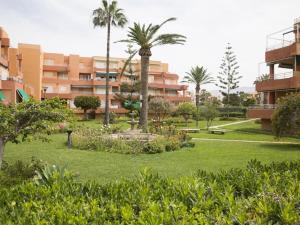 a park with a fountain and palm trees and buildings at Jardines del Mar Salobreña in Salobreña