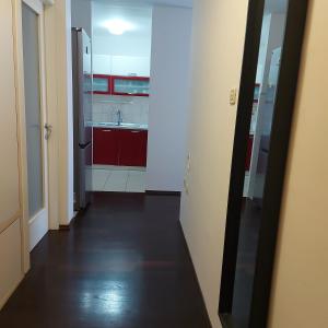un pasillo que conduce a una cocina con armarios rojos en Apartment Ivan, en Split