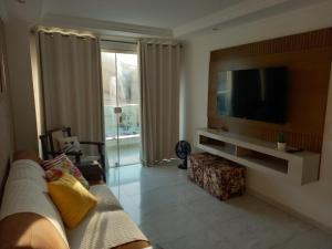 Il comprend un salon doté d'un canapé et d'une télévision à écran plat. dans l'établissement Apto de 2 quartos vista pro mar de Itaúna, à Saquarema