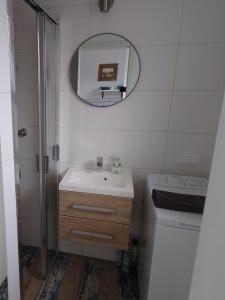 a white bathroom with a sink and a mirror at Całoroczne domki Morska Laguna in Kopalino
