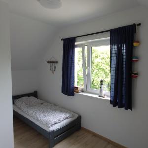 een slaapkamer met een bed en een raam bij Całoroczne domki Morska Laguna in Kopalino