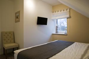 ein Schlafzimmer mit einem Bett und einem TV an der Wand in der Unterkunft "Strandvilla Seagull - Whg Sunset" in Grömitz