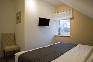 a bedroom with a bed and a tv on the wall at "Strandvilla Seagull - Whg Sunset" in Grömitz