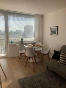 uma sala de estar com uma mesa e cadeiras e um sofá em Apartament Nowy Port em Gdansk