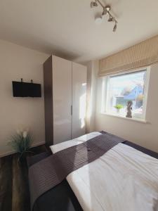 1 dormitorio con cama y ventana en "Seabreeze", en Grömitz