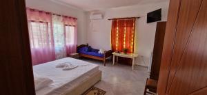 a bedroom with a bed and a couch and a window at Bar-Restaurant-Hotel-Familja in Klos