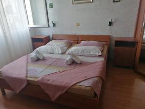1 dormitorio con 2 camas con sábanas y almohadas rosas en Apartments Katarina 2, en Makarska