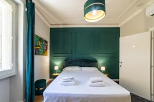 een slaapkamer met een groot bed met een groen hoofdeinde bij Room Eleven in Florence