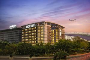 a rendering of a hotel with an airplane flying overhead at Novotel Guangzhou Baiyun Airport in Huadu