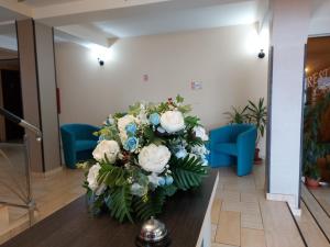 un bouquet de fleurs blanches et bleues sur une table dans l'établissement HOTEL CARMINA, à Rânca