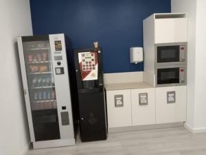 una cucina con distributore automatico e frigorifero di Hotel Hospedarte, SL a Riba-Roja De Túria