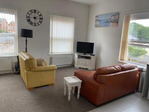 a living room with two chairs and a couch and a tv at Old Co Op House -Forest of Dean in Bream