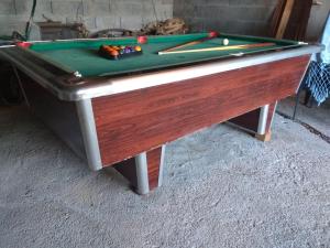 a pool table with two cues on top of it at Secondary home in Lobios