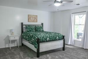 een slaapkamer met een bed met een groen dekbed en een raam bij Hunter's Cove in Morehead
