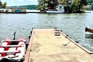 un barco está atracado en un muelle en el agua en Fully accessible lake house on its own island, en Andover