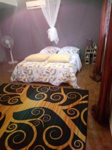 a bedroom with a bed and a rug on the floor at La Chambre bleue in Libreville