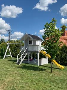 a house with a slide and a playground at Dom nad jeziorem in Jeziorany