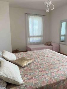 um quarto com uma cama grande e um sofá rosa em Appartamento incantevole centro Misano Adriatico em Misano Adriatico