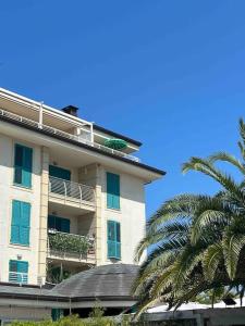 um edifício alto com uma palmeira em frente em Appartamento incantevole centro Misano Adriatico em Misano Adriatico