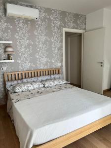 um quarto com uma cama e uma parede com papel de parede floral em Appartamento incantevole centro Misano Adriatico em Misano Adriatico