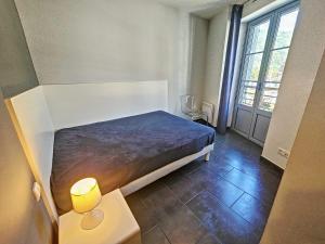 a bedroom with a bed and a large window at Appartement 4-6 couchages in Aulus-les-Bains