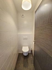 a bathroom with a white toilet and a door at Appartement 4-6 couchages in Aulus-les-Bains