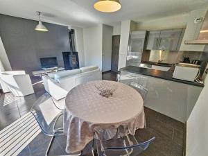 a kitchen with a table and chairs in a room at Appartement 4-6 couchages in Aulus-les-Bains