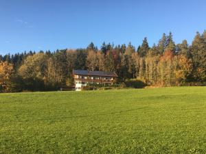 uma casa grande no meio de um campo em Ferienhaus am Wald em Friesenried
