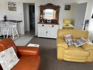 a living room with two couches and a kitchen at Old Co Op House -Forest of Dean in Bream