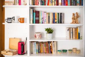 a white book shelf filled with books at Art House Radovljica in Radovljica