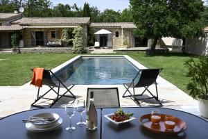 a table and two chairs and a swimming pool at Les Agapanthes de Gordes in Gordes