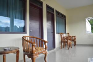 a group of chairs sitting on a porch at Hotel Toba Shanda By Helocus in Parapat