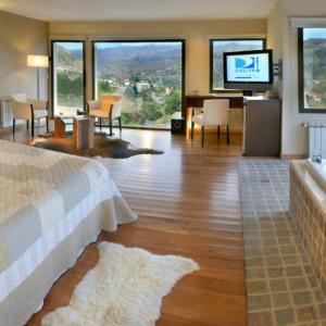a bedroom with a bed and a living room with a television at Suites de la Colina in La Cumbrecita