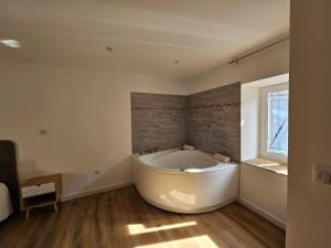 una gran bañera blanca en una habitación con ventana en Rue des Tilleuls en Saint-Marcel-lès-Sauzet