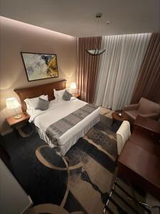 Hotel ALdoliaa في عنيزة: غرفة في الفندق مع سرير ومكتب