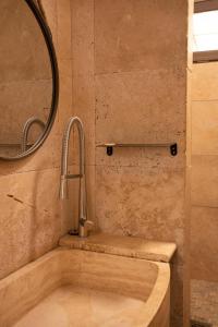 een badkamer met een bad, een wastafel en een spiegel bij SUZE LUXE NATURE in Suze-la-Rousse