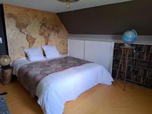 a bedroom with a white bed with a map on the wall at Aux alouettes in Landelies