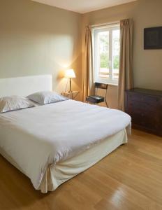 ein Schlafzimmer mit einem großen weißen Bett und einem Fenster in der Unterkunft La Maison de Charlotte in Doudeville