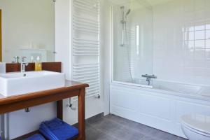 ein Badezimmer mit einem Waschbecken, einer Badewanne und einem WC in der Unterkunft La Maison de Charlotte in Doudeville