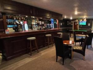 een bar met tafels en stoelen en een pooltafel bij Highland Bridge Hotel in Spean Bridge