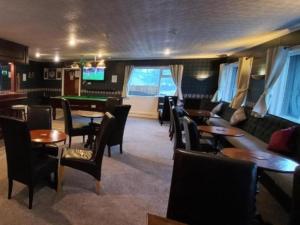 a restaurant with tables and chairs and a pool table at Highland Bridge Hotel in Spean Bridge